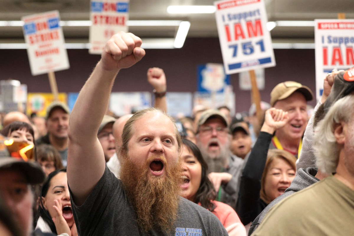 Ryan Bergh, a machinist at Boeing's factory in Everett, Washington for 10 years, cheers during a strike rally for the International Association of Machinists and Aerospace Workers (IAM) at the Seattle Union Hall in Seattle, Washington, on October 15, 2024. Photo by Jason Redmond / AFP.