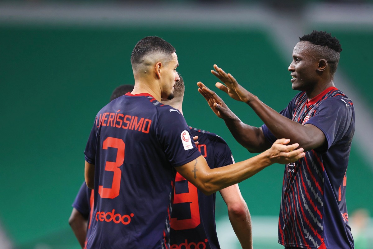 Al Duhail's Michael Olunga (right) is congratulated by teammates. 