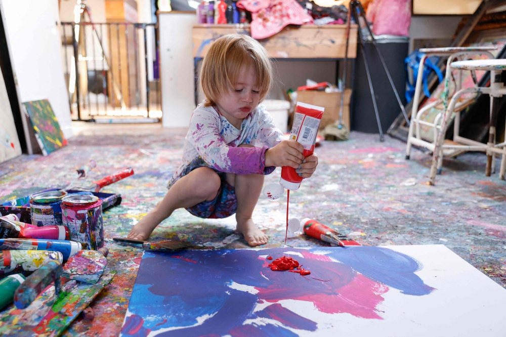 Laurent Schwarz, three years old, creates an artwork in his studio in his parents' house in Neubeuern near Rosenheim, southern Germany on October 17, 2024. (Photo by Michaela Stache / AFP)