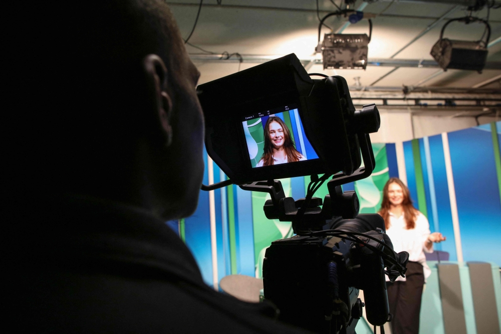 Czech Republic student, 19-year-old Denisa Lacinova is pictured through the monitor of a camera in the media room at the South East Technological University (SETU) in Carlow, eastern Ireland on September 24, 2024, where a new course has started in Content Creation and Social Media. Photo by PAUL FAITH / AFP