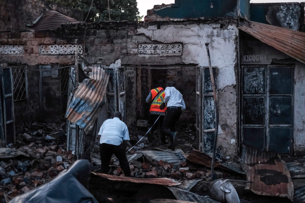 Forensic specialists and emergency responders inspect an area of destroyed houses following a fuel truck explosion in Kigogwa, on October 22, 2024. (Photo by Badru Katumba / AFP)