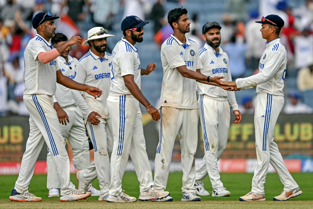 India's Washington Sundar (3R) celebrates with teammates after taking the wicket of New Zealand's Tim Southee in Pune on October 24, 2024. (Photo by Punit Paranjpe / AFP) 