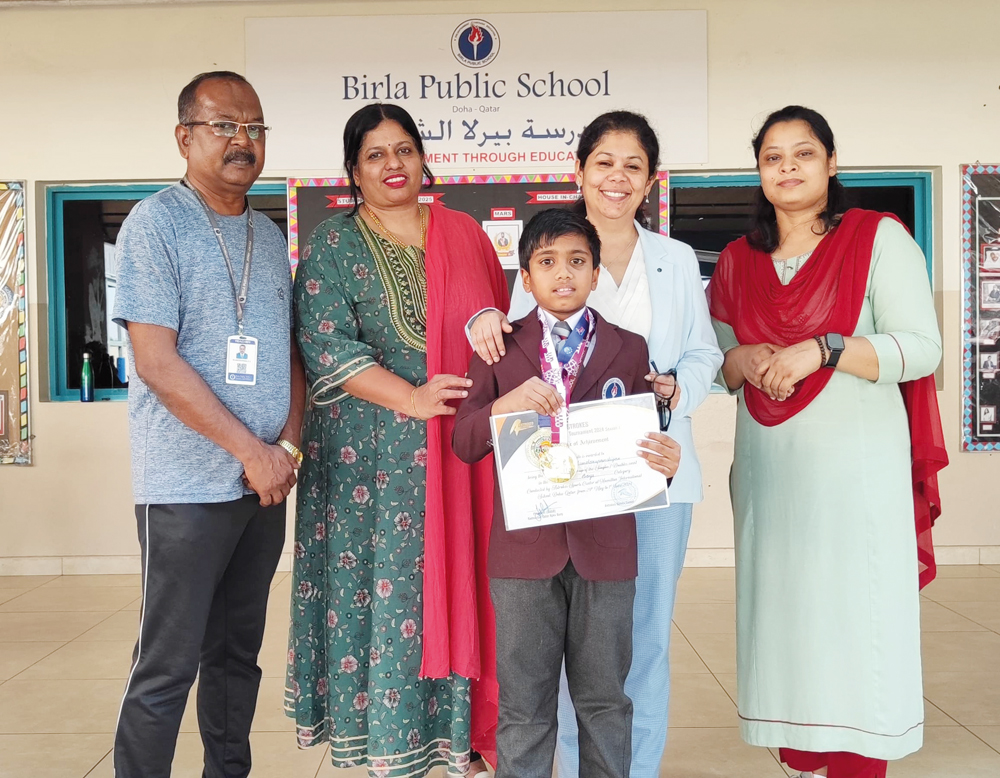 School staff with a student who topped a badminton tournament. 