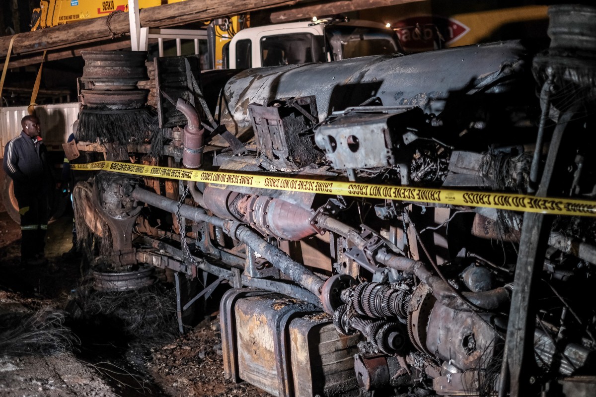 The charred wreckage of a fuel truck is marked as a crime scene following an explosion in Kigogwa, on October 22, 2024. Photo by Badru Katumba / AFP