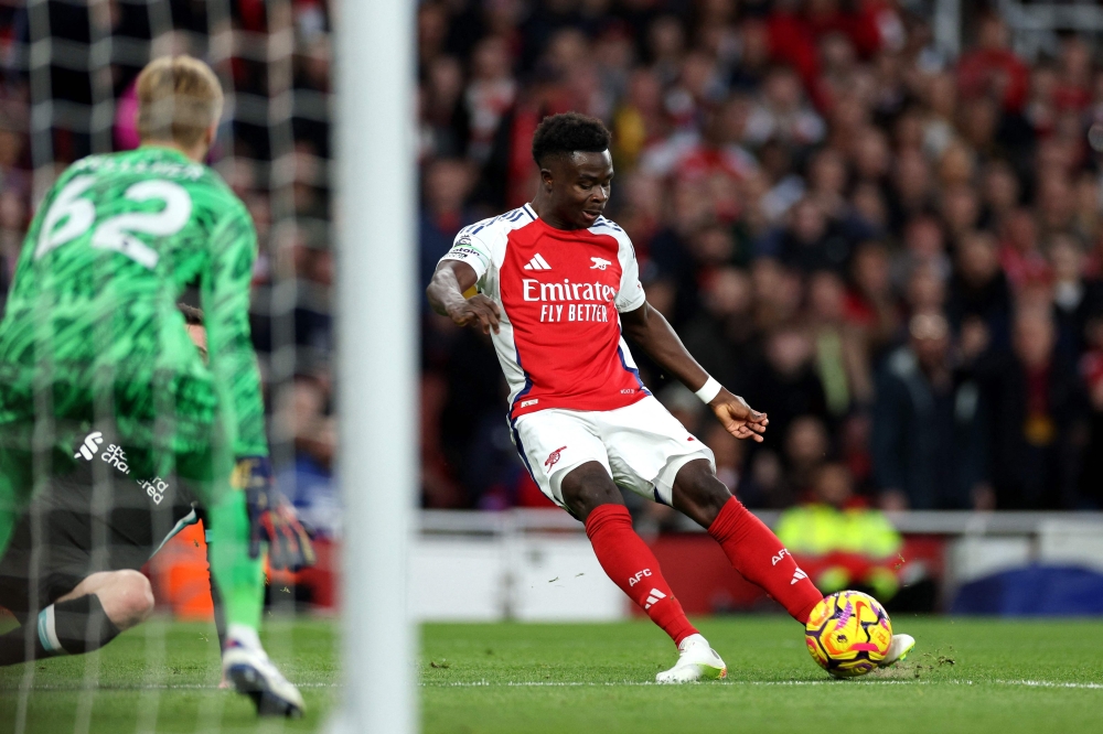 Arsenal's English midfielder #07 Bukayo Saka scores the team's first goal during the English Premier League football match between Arsenal and Liverpool at the Emirates Stadium in London on October 27, 2024. (Photo by Adrian Dennis / AFP) 