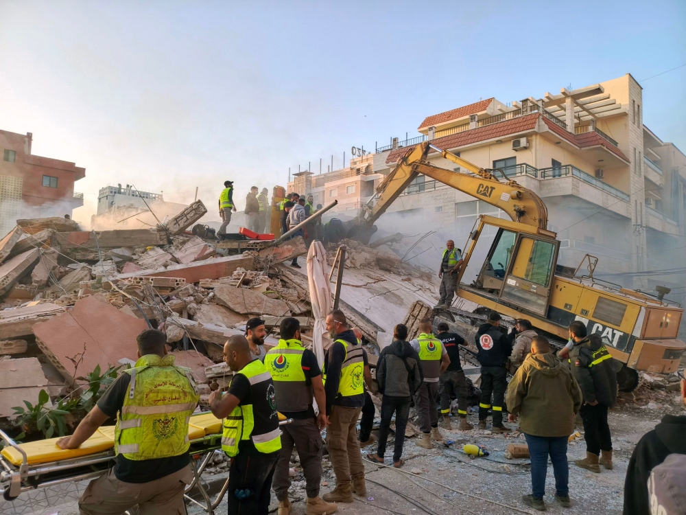 Rescuers search for survivors at the site of an Israeli airstrike that targeted overnight the southern Lebanese city of Tyre on October 28, 2024. (Photo by Kawnat Haju  / AFP)