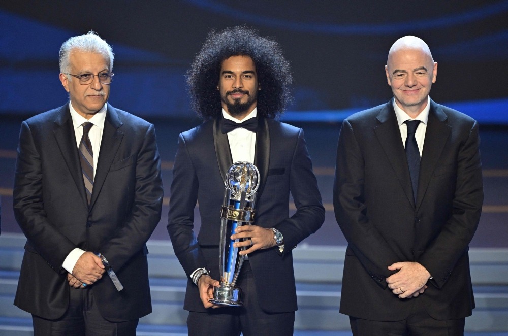 Qatar's forward Akram Afif (C) poses with FIFA president Gianni Infantino (R) and Sheikh Salman bin Ibrahim al-Khalifa (L), president of the Asian Football Confederation (AFC), after receiving the AFC Player of the Year award during the AFC Annual Awards 2023 ceremony in Seoul on October 29, 2024. (Photo by JUNG YEON-JE / AFP)