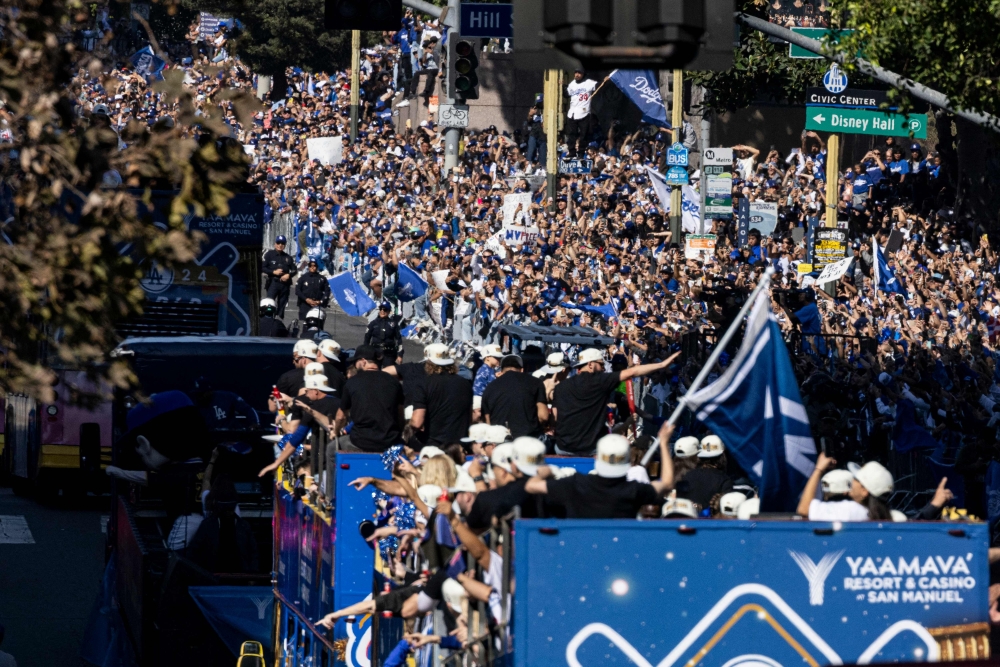 Los Angeles Dodgers’ players, staff, families and friends celebrate with fans during the Dodgers' World Series championship parade in downtown Los Angeles on November 1, 2024. (Photo by Etienne Laurent / AFP)