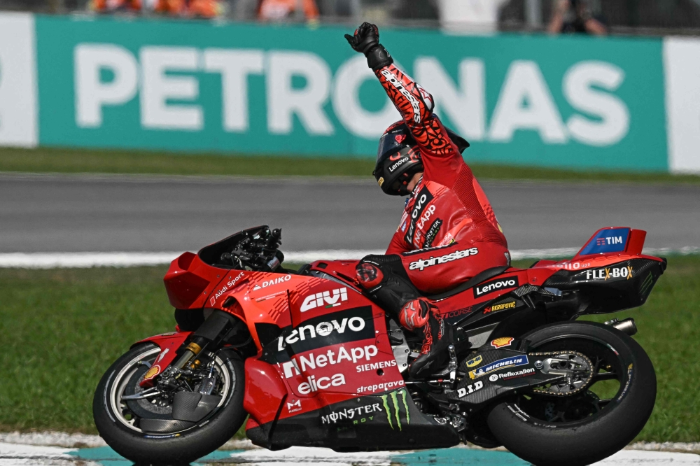 Ducati Lenovo Team's Italian rider Francesco Bagnaia celebrates as he crosses the finish line to win the MotoGP Malaysian Grand Prix at the Sepang International Circuit in Sepang on November 3, 2024. (Photo by Lillian Suwanrumpha / AFP)