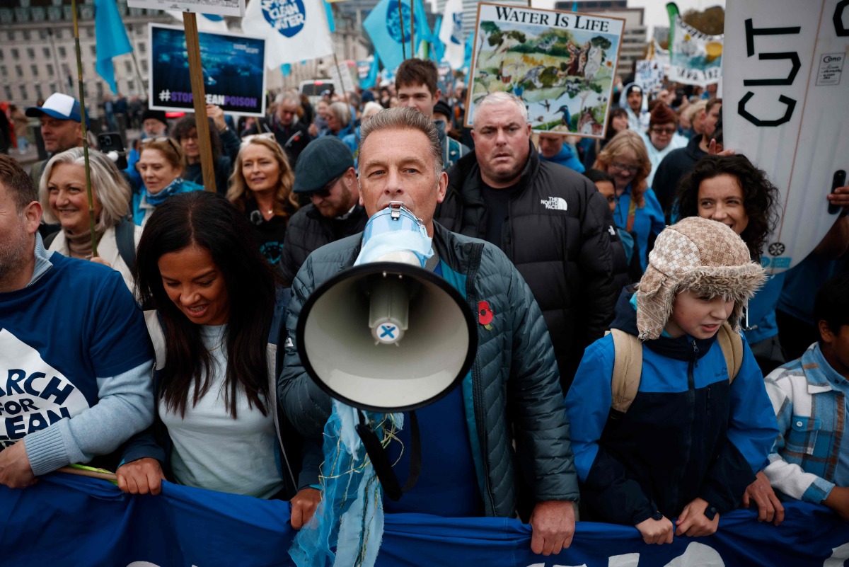 British environmentalist Chris Packham (C) joins protesters at a 