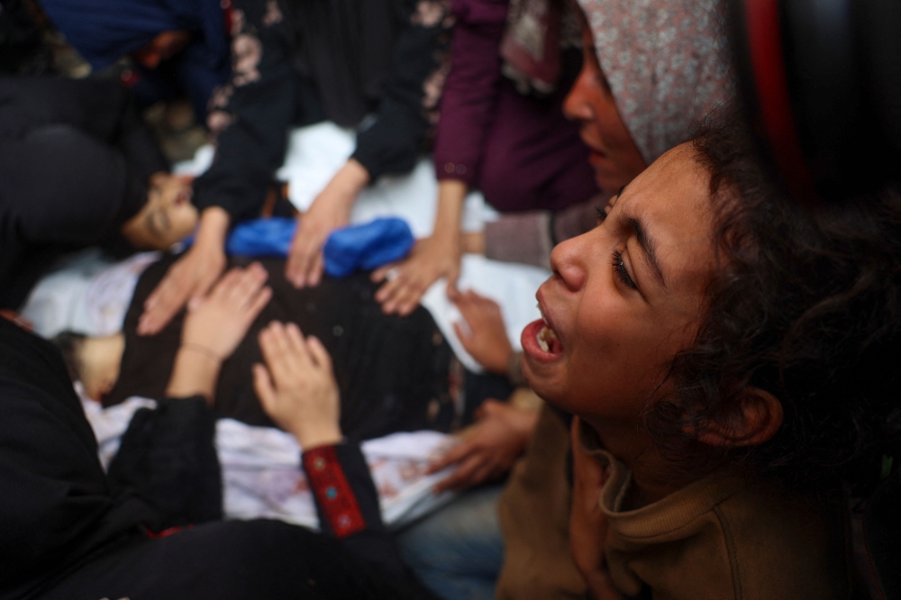 Relatives mourn over the bodies of Mahmoud Foura and his son Saad Foura who were killed during overnight Israeli bombardment, as they are prepared for burial at Al-Aqsa Martyrs hospital in Deir el-Balah in the central Gaza Strip on November 3, 2024. (Photo by Eyad Baba / AFP)