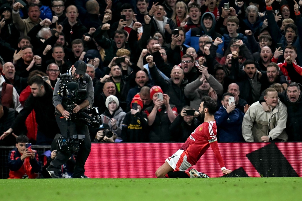 Manchester United's Portuguese midfielder #08 Bruno Fernandes celebrates scoring the team's first goal during the English Premier League football match between Manchester United and Chelsea at Old Trafford in Manchester, north west England, on November 3, 2024. (Photo by Paul Ellis / AFP) 