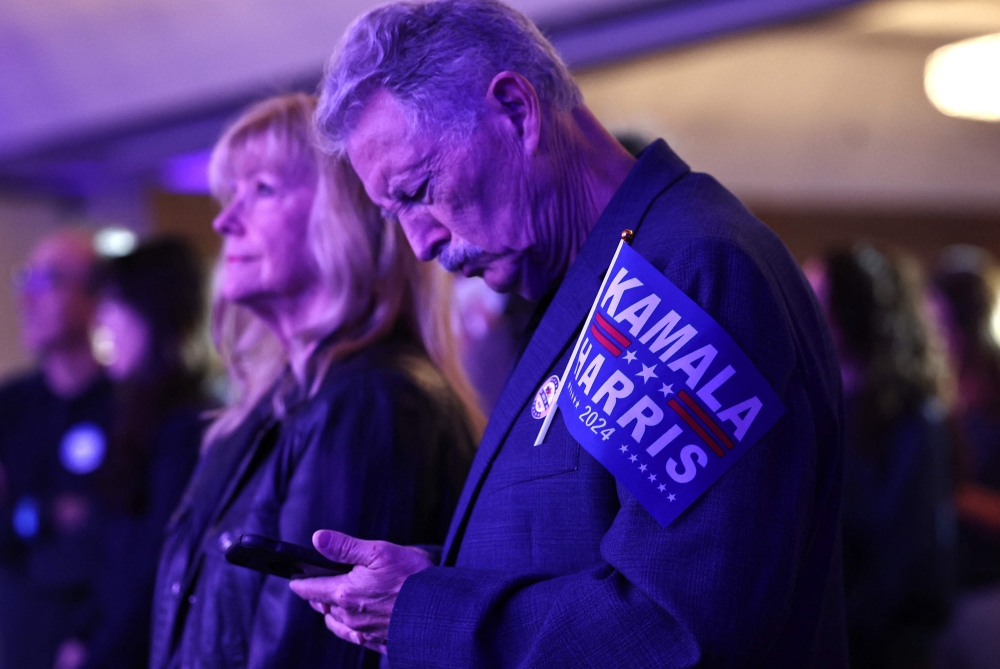 A supporter of Democratic presidential nominee, Vice President Kamala Harris checks his phone at an Arizona Democratic election night watch party on November 5, 2024 in Phoenix, Arizona. Mario Tama/Getty Images/AFP 