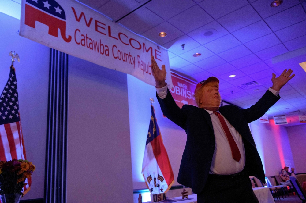 A man in a Trump mask greets the Catawba County Republicans at a watch party on November 5, 2024 in Newton, North Carolina. Melissa Sue Gerrits/Getty Images/AFP 