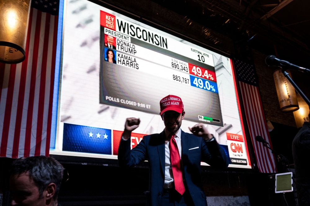 A supporter of US Presidential candidate Donald Trump poses for a picture at a restaurant as he follows the US election results in Mexico City on November 5, 2024. (Photo by Yuri Cortez / AFP)