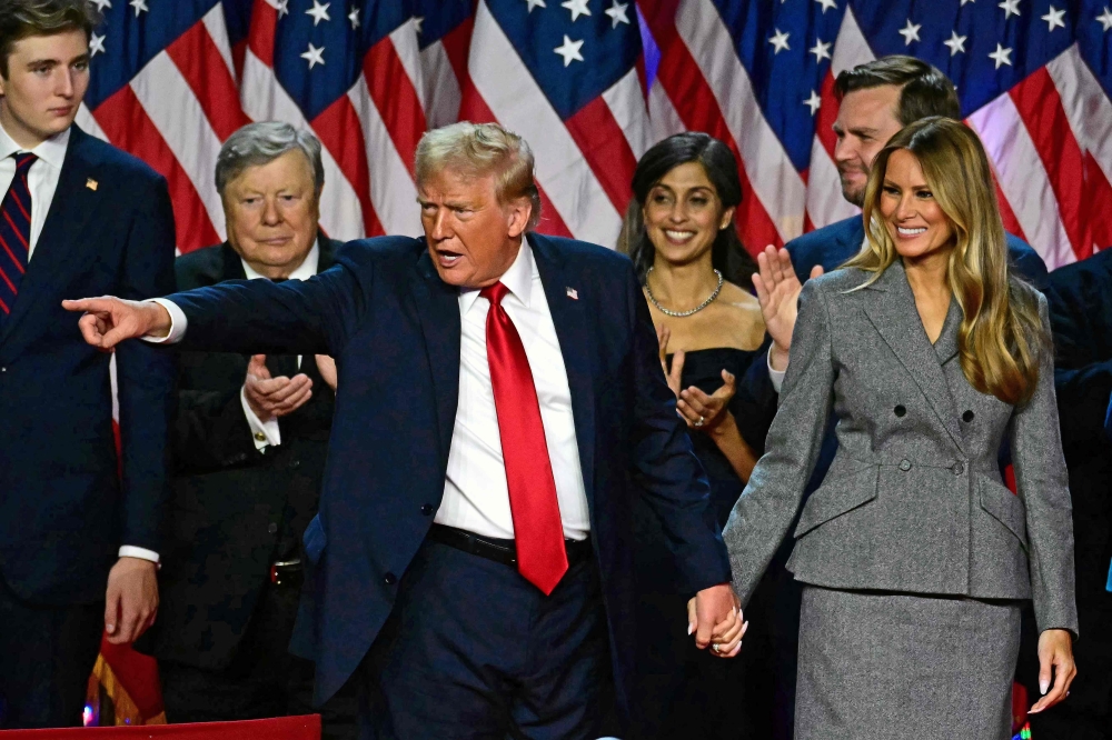 Former US President and Republican presidential candidate Donald Trump gestures at supporters after speaking during an election night event on November 6, 2024. (Photo by Jim Watson / AFP)