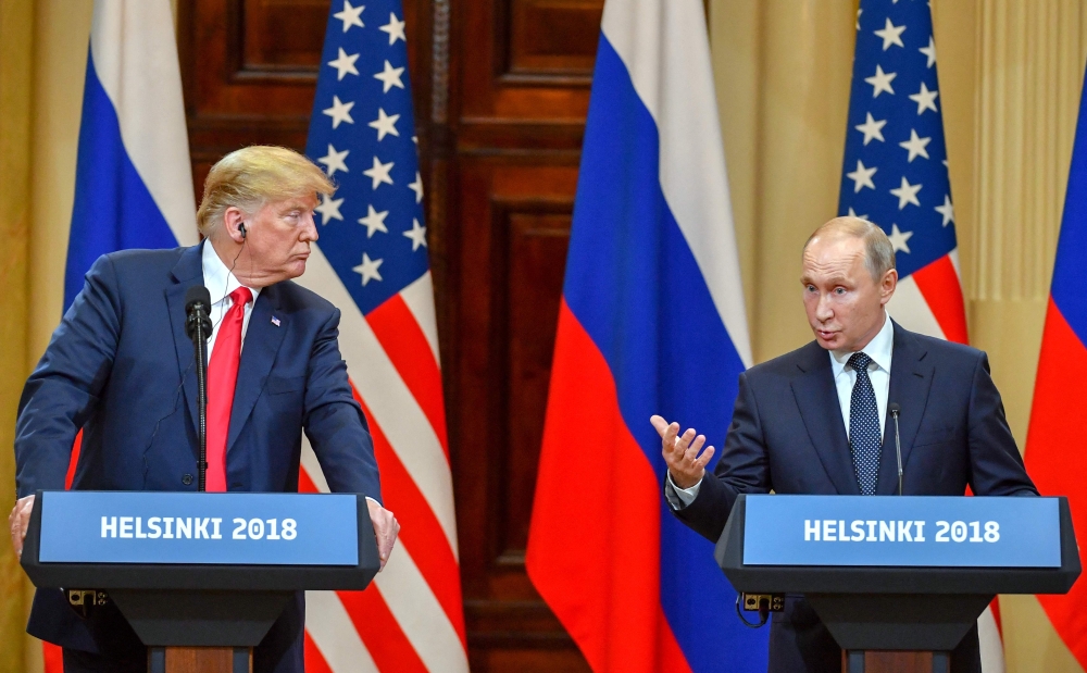 File: US President Donald Trump listens as Russia's President Vladimir Putin speaks during a joint press conference after a meeting at the Presidential Palace in Helsinki, on July 16, 2018. (Photo by Yuri Kadobnov / AFP)