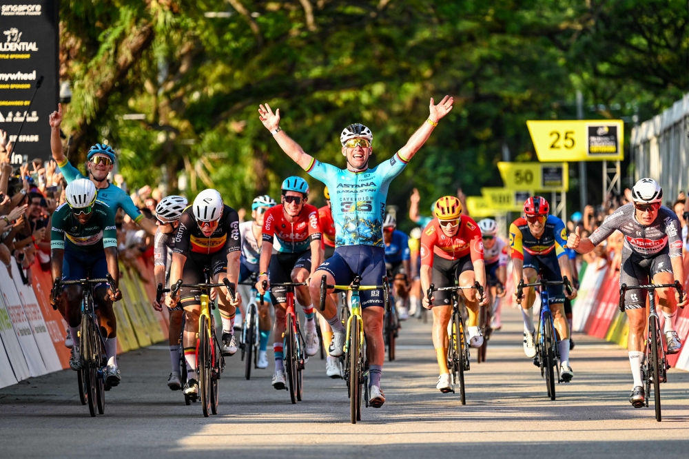 Britain's Mark Cavendish (C) celebrates as he crosses the finish line during the third Tour de France Singapore Criterium race in Singapore on November 10, 2024. (Photo by Roslan Rahman / AFP)