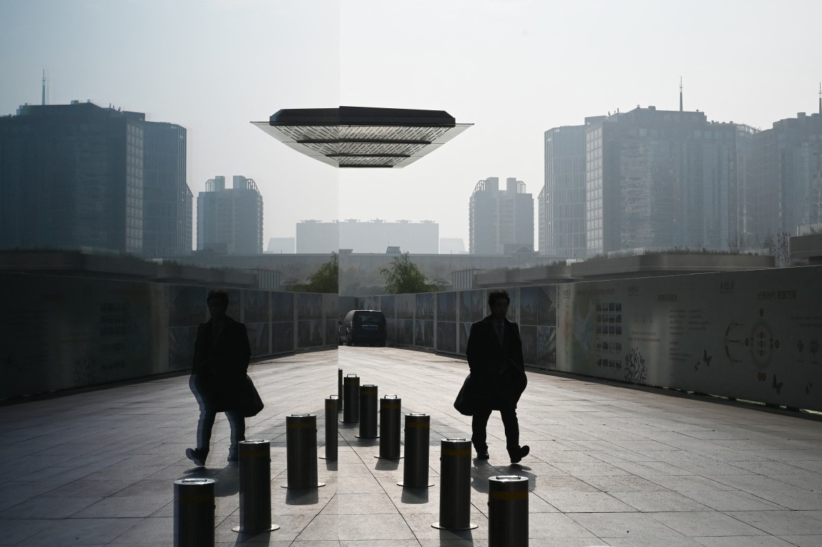 A man walks outside a building in the central business district in Beijing on November 10, 2024. (Photo by Greg Baker / AFP)