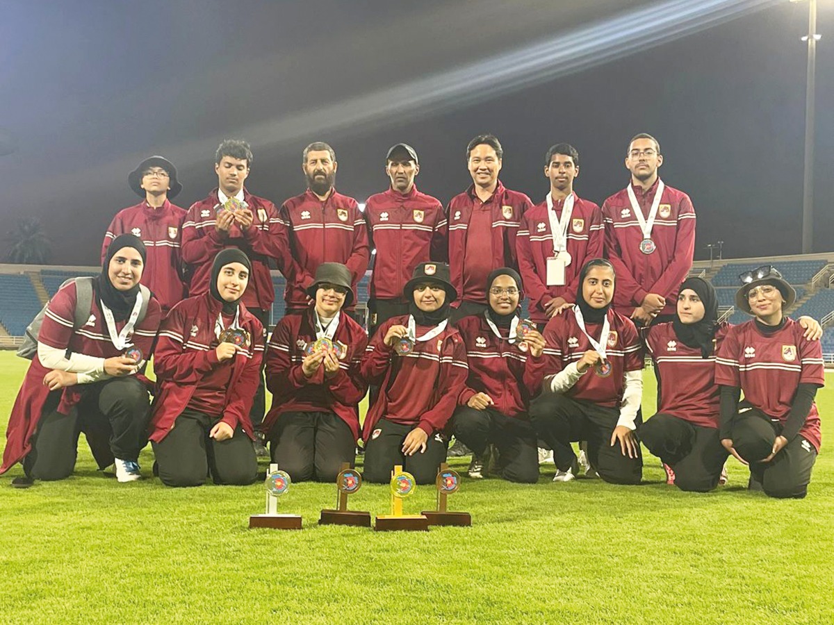 Qatar archers and officials pose for a photograph. 