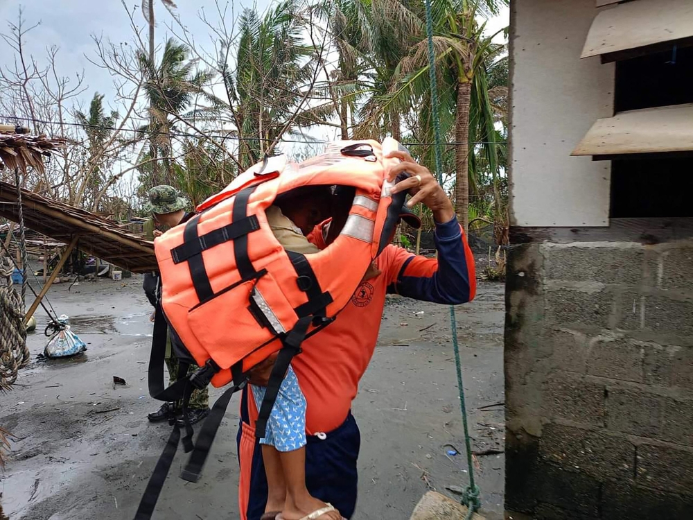 This handout photo taken on November 14, 2024, shows a rescuer carrying a young resident during a forced evacuation operation in Buguey town, Cagayan province, north of Manila. (Photo by Handout / Buguey Municipal Disaster Risk and Reduction Management Office via Cagayan Provincial Public Information Office / AFP) 