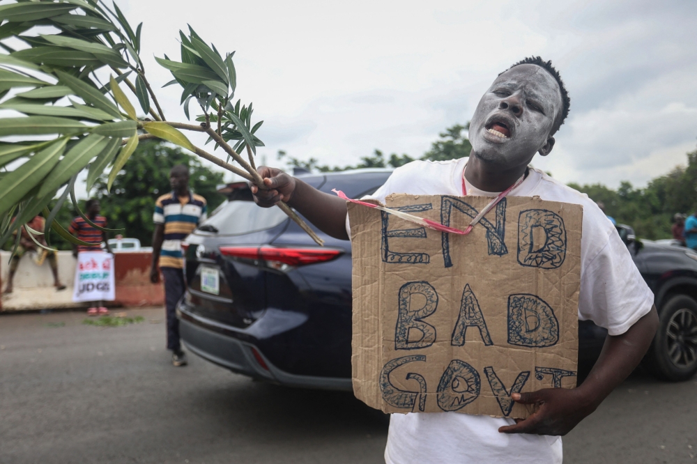 File: A protestor hold a placard a protest against  high living costs in Africa’s most-populous nation, in Abuja on August 2, 2024. (Photo by Kola Sulaimon / AFP)

