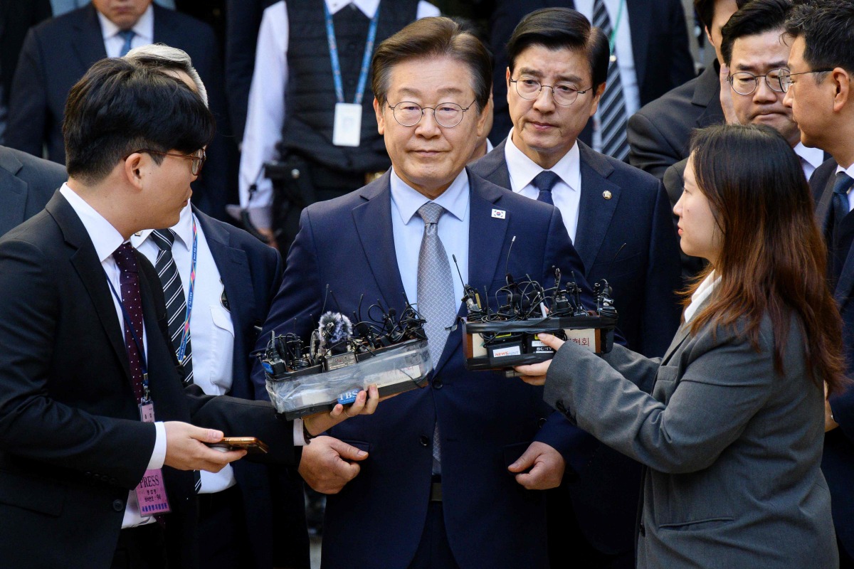 South Korean opposition leader Lee Jae-myung (C) leaves the Seoul Central District Court in Seoul on November 15, 2024, after he was found guilty of making false statements in violation of the Public Official Election Act. (Photo by ANTHONY WALLACE / AFP)