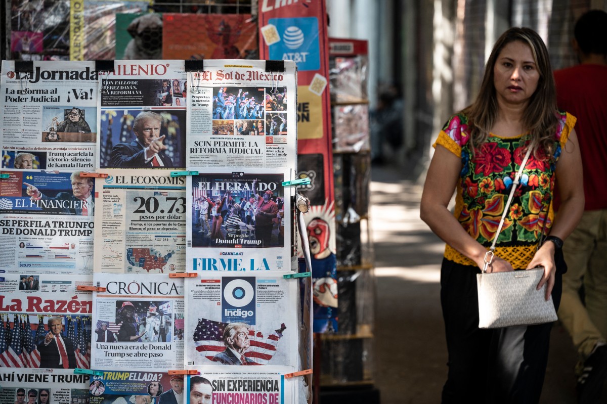 Photo used only for demonstration purposes. A woman walks past a newspaper kiosk displaying front pages with news about the US presidential election in Mexico City on November 6, 2024. Photo by Yuri CORTEZ / AFP.