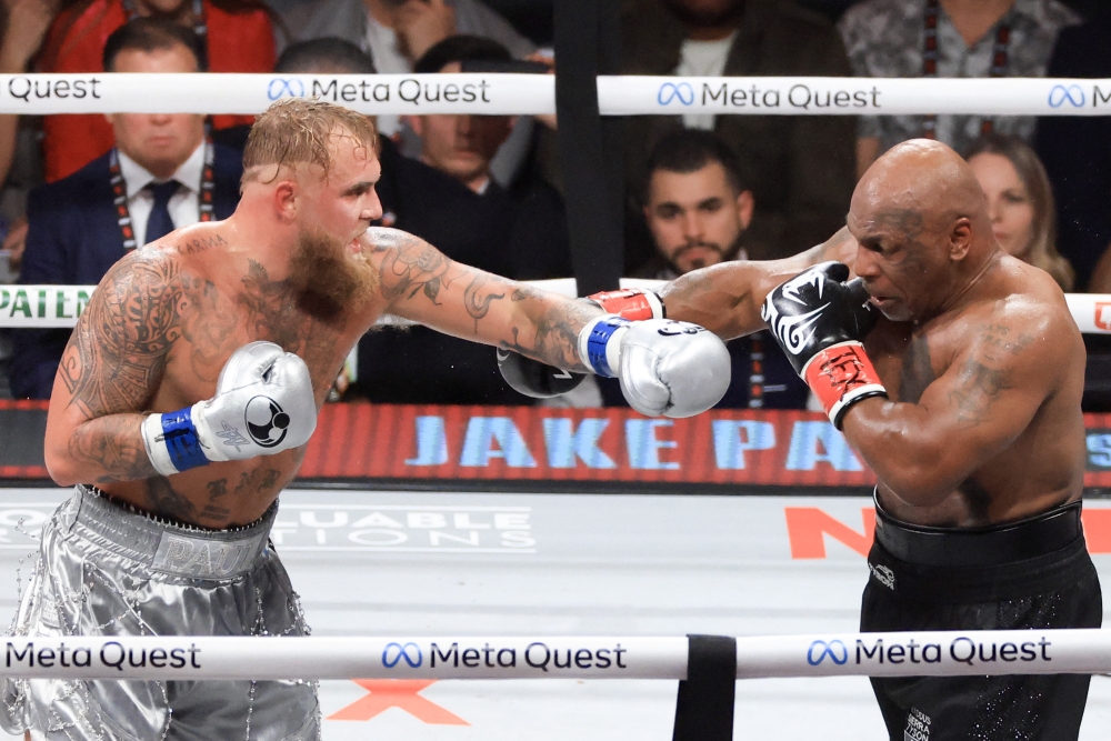 Jake Paul (L) and Mike Tyson throw punches during their heavyweight bout at AT&T Stadium on November 15, 2024 in Arlington, Texas. Christian Petersen/Getty Images/AFP 