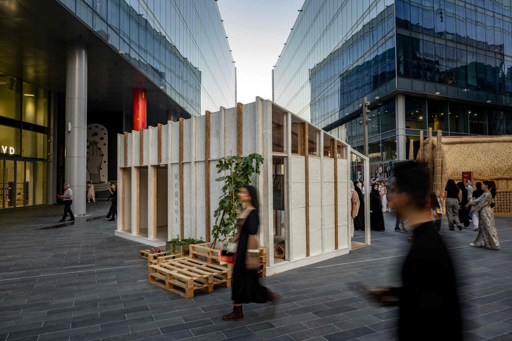 Visitors walk past a mycelium-based modular shelter, designed by the ReRoot initiative during the annual Design Week in Dubai on November 9, 2024. (Photo by Fadel Senna / AFP)