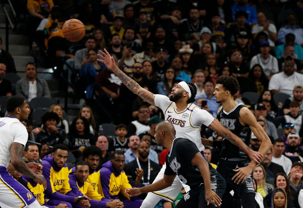 Anthony Davis #3 of the Los Angeles Lakers reaches for a pass as he is guarded by Victor Wembanyama #1 of the San Antonio Spurs in the first half the Emirates NBA Cup game at the Frost Bank Center on November 15, 2024 in San Antonio, Texas. Ronald Cortes/Getty Images/AFP 