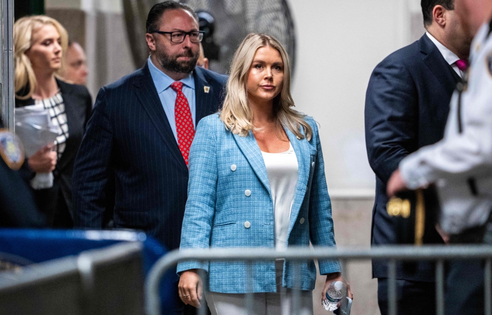 (Files) Trump campaign press secretary Karoline Leavitt (C) and Trump adviser Jason Miller (L) arrive at the criminal trial of former US President and Republican presidential candidate Donald Trump's criminal trial at Manhattan Criminal Court in New York City on May 29, 2024. (Photo by Doug Mills / POOL / AFP)