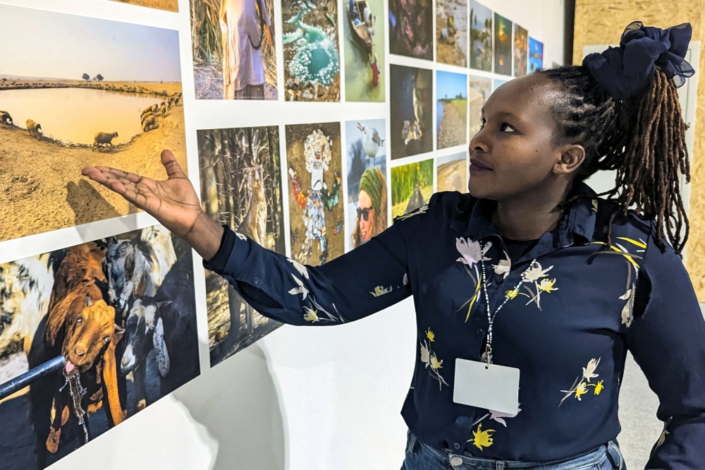 Kenyan climate scientist Joyce Kimutai points at a photograph during the United Nations Climate Change Conference (COP29) in Baku on November 15, 2024. (Photo by Nick Perry / AFP)