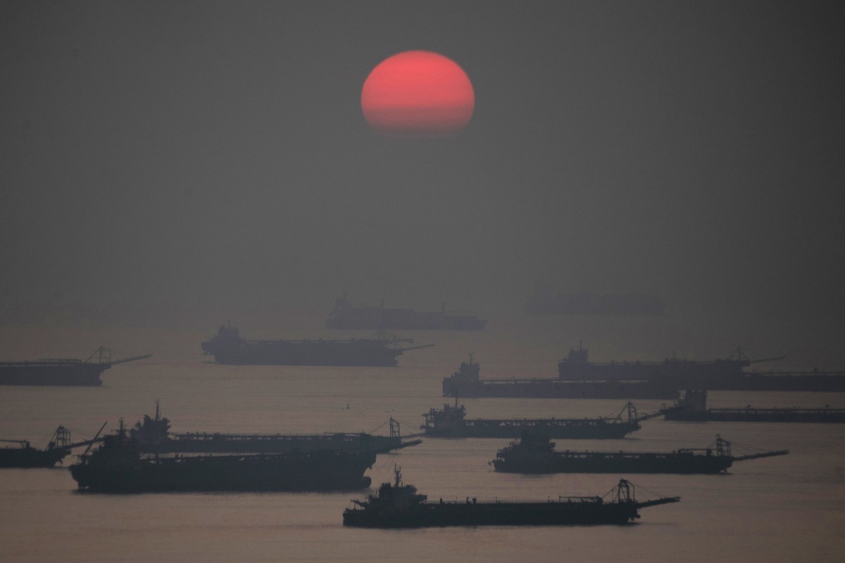 The sun sets past anchored barges ahead of the expected landfall of Super Typhoon Man-yi, in Manila Bay on November 16, 2024. A super typhoon sweeping towards the Philippines on November 16 was intensifying and could have a 