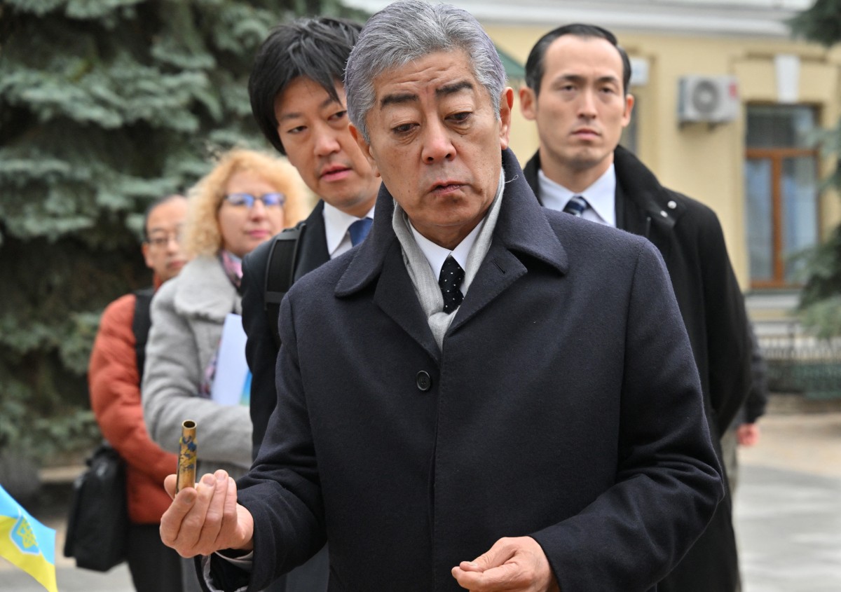 Japan's Foreign Minister Takeshi Iwaya (C) holds a cartridge sold by volunteers to raise money for the needs of Ukrainian army, as he visits the Saint Michael's Cathedral in Kyiv, on November 16, 2024. Photo by Sergei SUPINSKY / AFP.