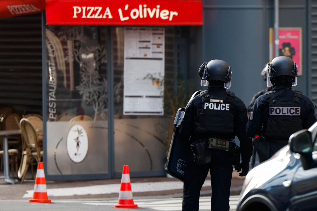 Police officers stand outside the restaurant 