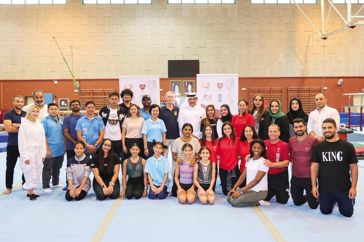 QGF President Ali Al Hitmi poses for a group photo with participating coaches and gymnasts. 