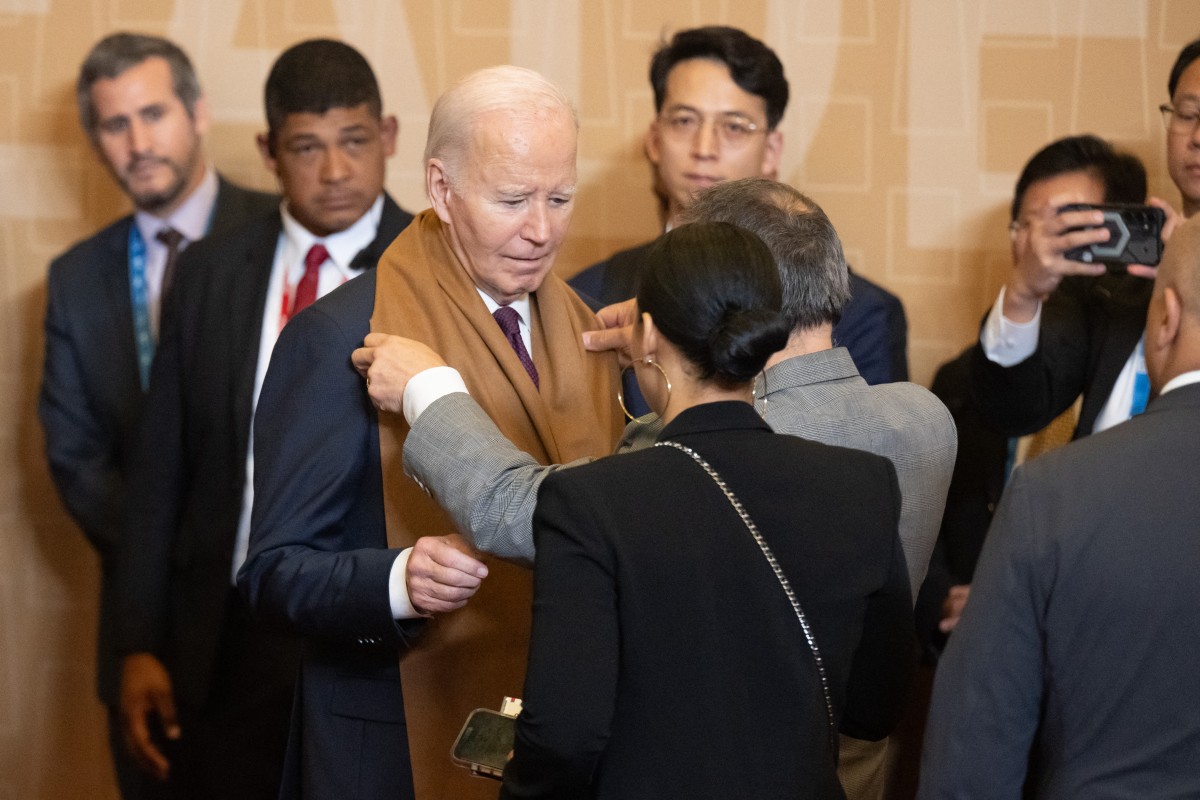 US President Joe Biden has his scarf adjusted prior to a family photo during the Asia-Pacific Economic Cooperation (APEC) Leaders’ Retreat summit in Lima, Peru, November 16, 2024. (Photo by SAUL LOEB / AFP)