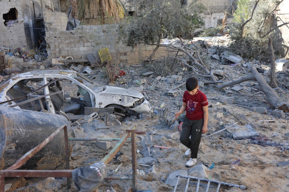 A boy walks on the rubble of a house destroyed in an Israeli strike on al-Jalaa street in central Gaza City on November 18, 2024. Photo by Omar AL-QATTAA / AFP