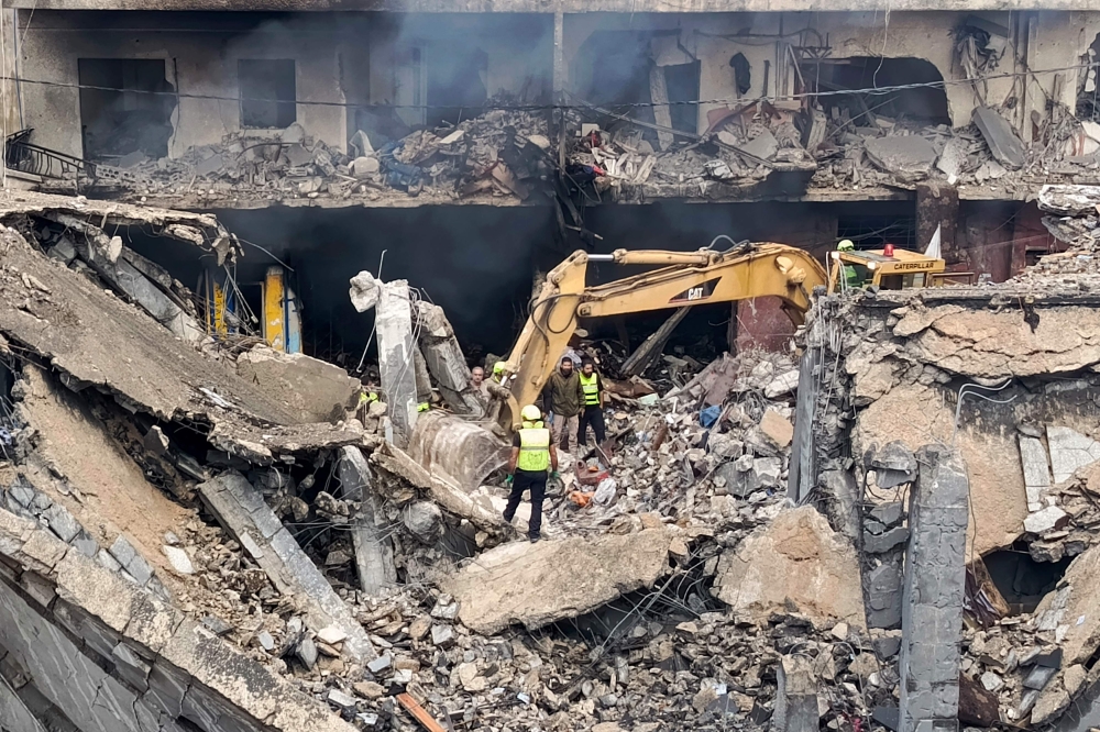 Civil Defence teams look for survivors amid the rubble of a destroyed house at the scene of an overnight airstrike that targeted the eastern entrance of the southern Lebanese city of Tyre on November 19, 2024. (Photo by Kawnat Haju / AFP)