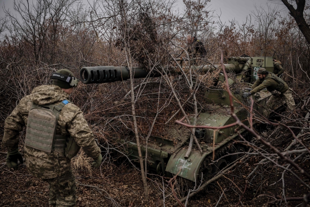 Ukrainian servicemen of the 24th Mechanized Brigade camouflage a 2s5 152 mm self-propelled howitzer at an undisclosed location near Chasiv Yar in Donetsk region on November 18, 2024. (Photo by Handout / 24th Mechanized Brigade of Ukrainian Armed Forces / AFP) 