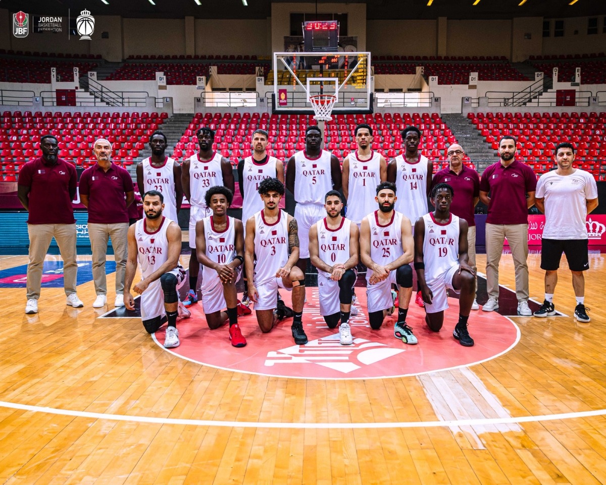 Qatar basketball team players and officials pose for a photo.