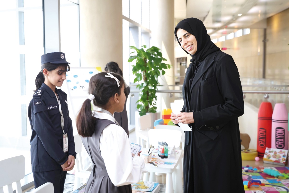 Minister of Education and Higher Education H E Lolwah bint Rashid Al Khater interacts with students displaying their works at an exhibition to mark the day. 