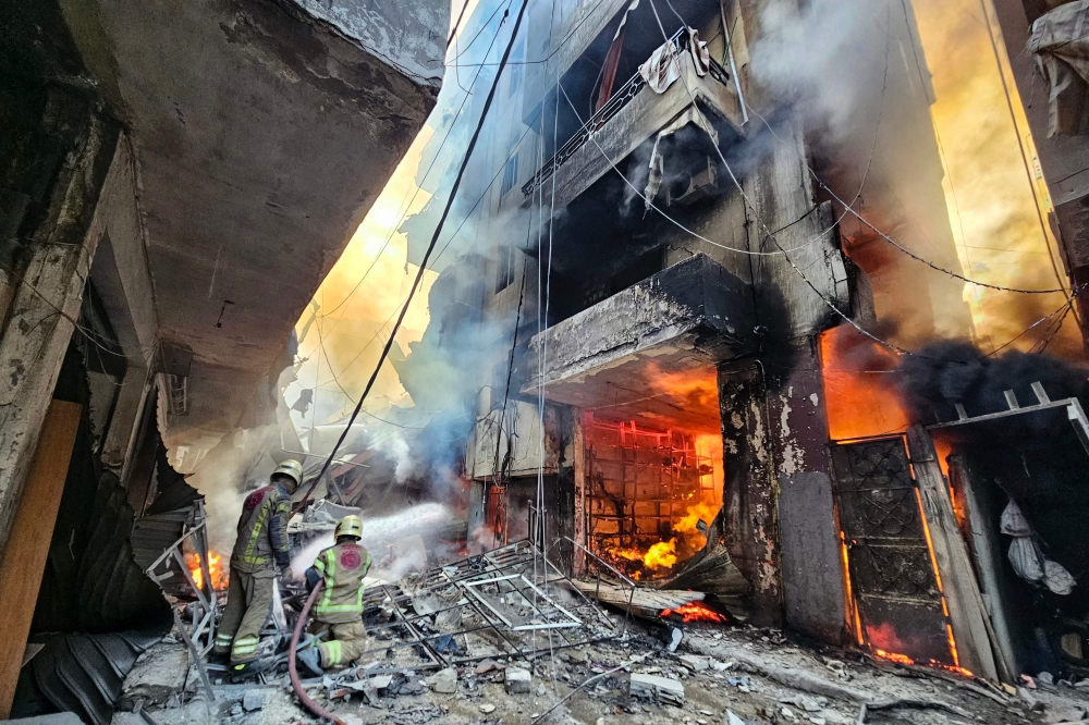 Firefighters battle the flames after a building was hit in an Israeli airstrike in the Haret Hreik neighbourhood of Beirut's souther suburbs on November 23, 2024. (Photo by AFP)