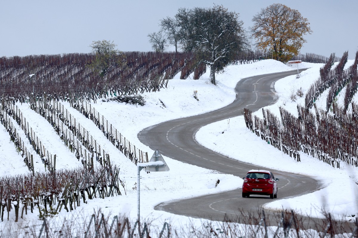 A car runs through the vineyards covered by snow near Andlau, eastern France, on November 22, 2024. Photo by FREDERICK FLORIN / AFP.