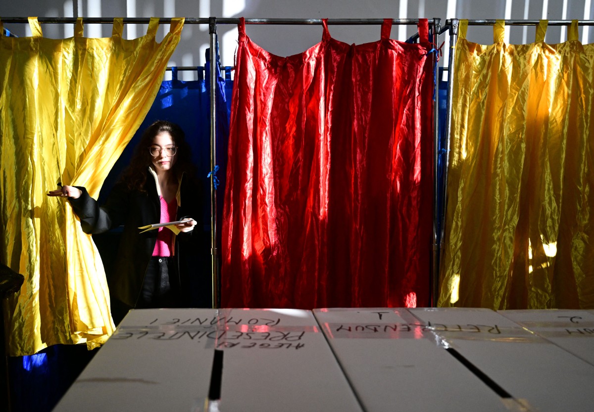 A woman leaves the polling booth prior to vote for the presidential elections at a polling station in Bucharest on November 24, 2024. Photo by Daniel MIHAILESCU / AFP.