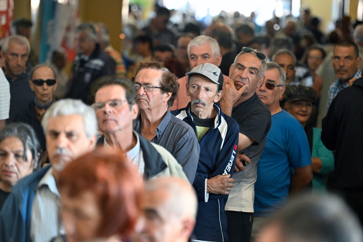 People queue to vote during the presidential runoff election in Montevideo on November 24, 2024. (Photo by Santiago Mazzarovich / AFP)
