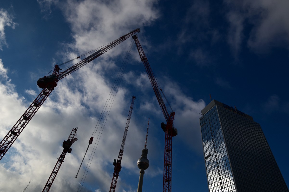 Photo used for representation purposes. Clouds cover the sky as cranes operate at a building and construction site close to the TV tower (C) and Park Inn Hotel (R) at Alexanderplatz square in Berlin, Germany on November 22, 2024. Photo by Tobias SCHWARZ / AFP.