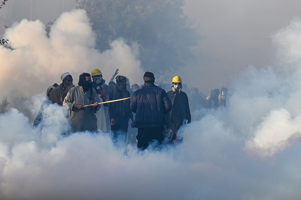 Policemen fire tear gas shells to disperse supporters of Pakistan Tehreek-e-Insaf (PTI) party during a protest to demand the release of former prime minister Imran Khan, in Islamabad on November 26, 2024. (Photo by Aamir Qureshi / AFP)