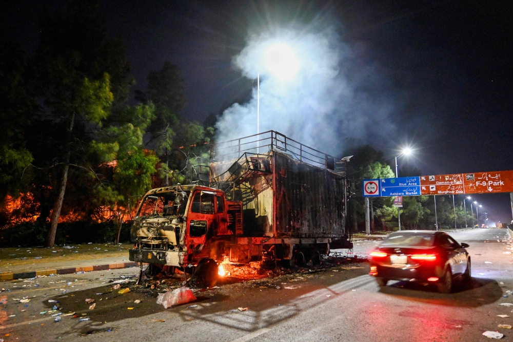 A rally truck used by Bushra Bibi, the wife of Pakistan's former prime minister Imran Khan, burns near the red zone after a protest to demand Khan's release, in Islamabad on November 27, 2024. (Photo by Aamir Qureshi / AFP)
 